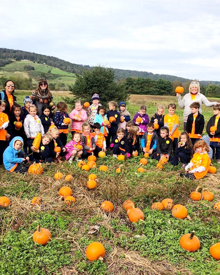 Students posing with pumpkins during a Great Country Farms field trip