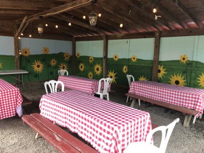 Sunflower Hut kid’s birthday party or corporate picnic venue outfitted with picnic tables and red checked table covers at Great Country Farms in Northern Virginia.