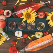 Sunflowers and bottles of Hard Cider surround a flight of Henway Hard Cider next to Great Country Farms in Northern Virginia.