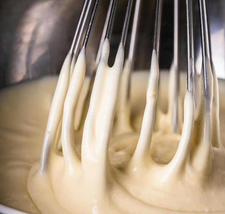 Butter being made in a bowl with a whisk