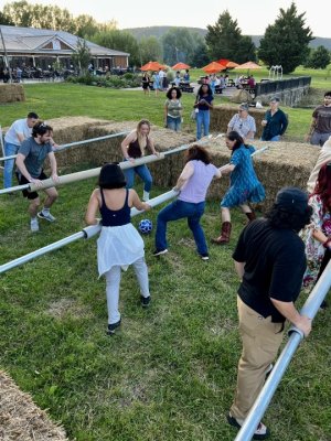 Guests at Adult Camp at The Henway Cider Barn, next to Great Country Farms in Bluemont Virginia play human foosball on a life-size foosball court.